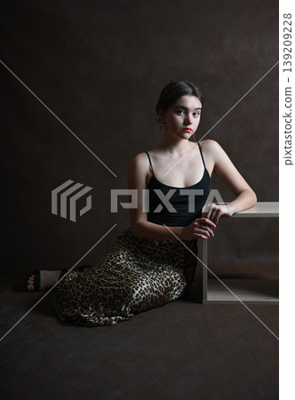 Teenage girl with dark hair poses in the studio 139209228