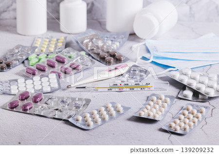 Thermometers and a variety of medicines for treatment on the table Thermometers and a variety of medicines for treatment on the table 139209232