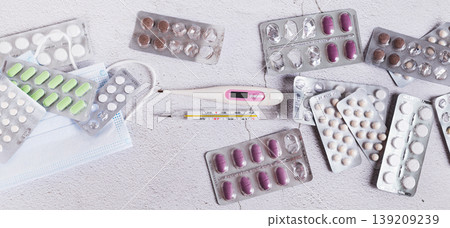 Blister packs with pills, medical masks and thermometers on the table top view web banner Blister packs with pills, medical masks and thermometers on the table top view web banner 139209239