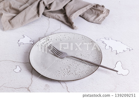 Concept of world hunger, empty plate and fork on the table Concept of world hunger, empty plate and fork on the table 139209251