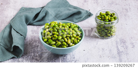 Frozen green peeled edamame beans in a bowl on a table web banner Frozen green peeled edamame beans in a bowl on a table web banner 139209267