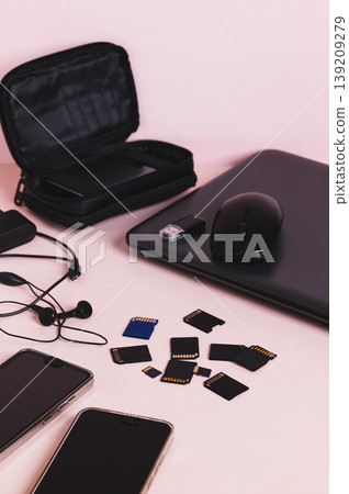 Flash drives, smartphones, a laptop, headphones, and a hard drive on the table vertical view Flash drives, smartphones, a laptop, headphones, and a hard drive on the table vertical view 139209279