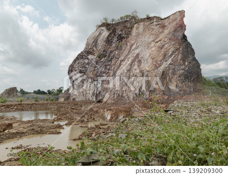 The Grand Canyon Chanthaburi reveals a scene of raw, monolithic beauty where a massive cliff of striated stone rises like a fortress against a soft, overcast sky. Once the heart of the Nong Bua Old The Grand Canyon Chanthaburi reveals a scene of raw, monolithic beauty where a massive cliff of striated stone rises like a fortress against a soft, overcast sky. Once the heart of the Nong Bua Old 139209300