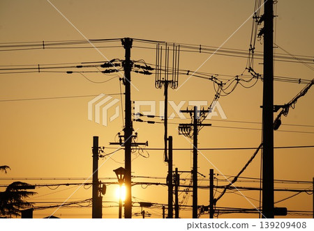 Utility poles, power lines, and a twilight landscape Utility poles, power lines, and a twilight landscape 139209408