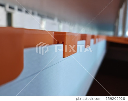 Close up side view of orange plastic slatted flooring panel edge with locking tabs installed on support beam in pig farm. Livestock farming, agriculture equipment, construction Close up side view of orange plastic slatted flooring panel edge with locking tabs installed on support beam in pig farm. Livestock farming, agriculture equipment, construction 139209928