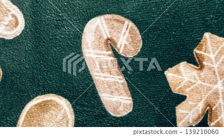 cozy christmas candy cane, snowflake, and cookie pattern on green textured fabric for holiday branding 139210060