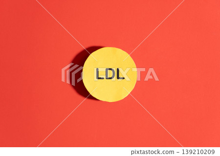 High cholesterol concept. LDL cholesterol with yellow spherical particles inside blood on red background. Cardiovascular disease problem. 139210209