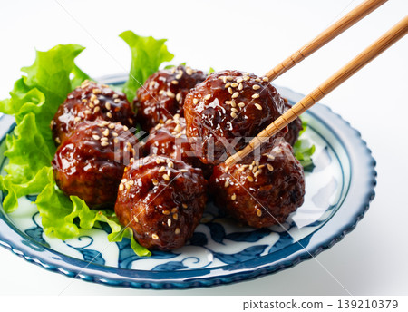 Sweet and sour meatballs with a glossy sheen, lifted with chopsticks (white background, white backdrop, lifted with chopsticks) Sweet and sour meatballs with a glossy sheen, lifted with chopsticks (white background, white backdrop, lifted with chopsticks) 139210379