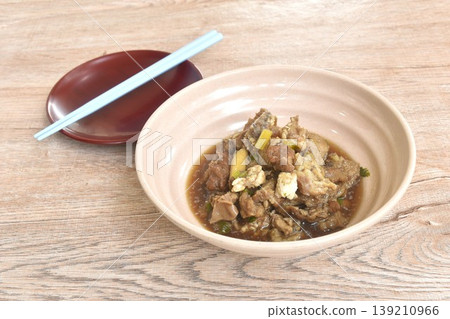 boiled braised beef meat and tendon in herb brown soup on bowl with plate and chopsticks 139210966