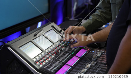 Mixing operation. Professional audio or sound engineers operating digital mixing consoles in studio or live mix perform. Sound control music production broadcasting mix and live event audio technology Mixing operation. Professional audio or sound engineers operating digital mixing consoles in studio or live mix perform. Sound control music production broadcasting mix and live event audio technology 139210989