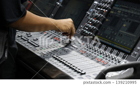 Mixing operation. Professional audio or sound engineers operating digital mixing consoles in studio or live mix perform. Sound control music production broadcasting mix and live event audio technology Mixing operation. Professional audio or sound engineers operating digital mixing consoles in studio or live mix perform. Sound control music production broadcasting mix and live event audio technology 139210995
