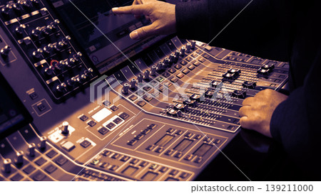 Mixing operation. Professional audio or sound engineers operating digital mixing consoles in studio or live mix perform. Sound control music production broadcasting mix and live event audio technology Mixing operation. Professional audio or sound engineers operating digital mixing consoles in studio or live mix perform. Sound control music production broadcasting mix and live event audio technology 139211000
