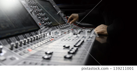 Mixing operation. Professional audio or sound engineers operating digital mixing consoles in studio or live mix perform. Sound control music production broadcasting mix and live event audio technology Mixing operation. Professional audio or sound engineers operating digital mixing consoles in studio or live mix perform. Sound control music production broadcasting mix and live event audio technology 139211001