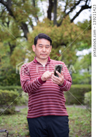一位拿著智慧型手機的中年男子 139211423