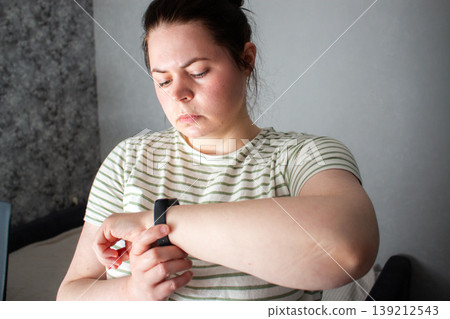 Person glancing at smartwatch briefly then returning to everyday routine. Health data as quiet check not lifeline. Calm tracking without anxiety. Tech supports not controls concept 139212543