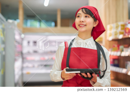 一位年輕女子正在使用平板電腦管理產品。 139212569