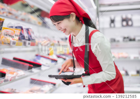 一位年輕女子正在使用平板電腦管理產品。 139212585