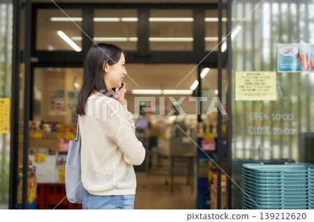 A young woman shopping with a shopping cart at a supermarket. A young woman shopping with a shopping cart at a supermarket. 139212620