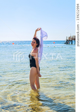 A mature woman enjoys the warm sea and sun on vacation 139212994