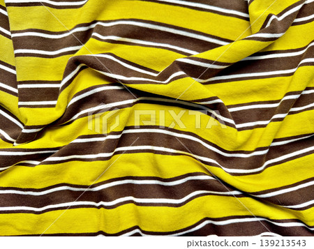 vibrant yellow brown striped knit fabric wrinkled texture closeup autumnal folds cozy fashion material background 139213543