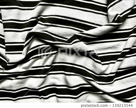crumpled black white striped fabric folds in soft textile texture closeup evoking minimalist fashion elegance crumpled black white striped fabric folds in soft textile texture closeup evoking minimalist fashion elegance 139213544