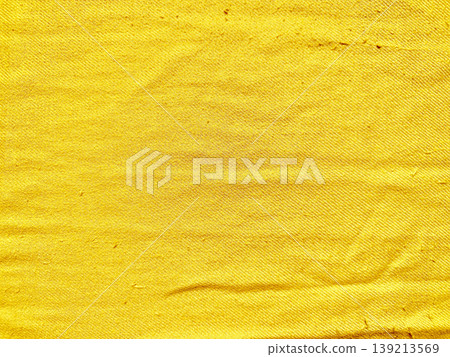 vibrant crumpled yellow fabric closeup showcasing textured weave and subtle fade against soft blue backdrop 139213569