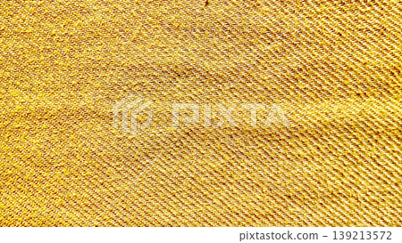 golden yellow denim fabric texture closeup revealing intricate diagonal twill weave and warm fibrous details golden yellow denim fabric texture closeup revealing intricate diagonal twill weave and warm fibrous details 139213572