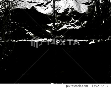 crumpled aluminum foil closeup revealing shiny metallic wrinkles dark shadows abstract texture evoking mysterious industrial mood in macro composition crumpled aluminum foil closeup revealing shiny metallic wrinkles dark shadows abstract texture evoking mysterious industrial mood in macro composition 139213597