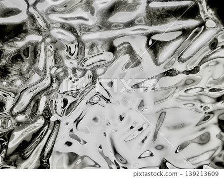 crumpled metallic foil abstract texture shimmering black white waves fluid patterns twisting ethereal closeup 139213609