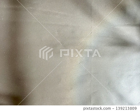 crumpled beige fabric texture shimmering under soft light with gentle folds and gradient shadows 139213809