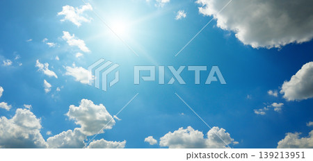 Clear blue sky with white fluffy clouds and bright radiant sun. Clear blue sky with white fluffy clouds and bright radiant sun. 139213951