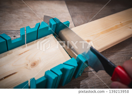 A scene of cutting wood with a saw during a DIY project. A scene of cutting wood with a saw during a DIY project. 139213958