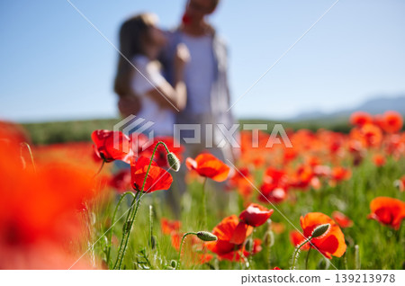Couple Embracing in Sunlit Red Poppy Field on a Clear Summer Day Couple Embracing in Sunlit Red Poppy Field on a Clear Summer Day 139213978