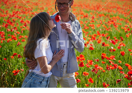 Young Couple Embracing in Sunny Red Poppy Field Sharing a Romantic Moment Together Young Couple Embracing in Sunny Red Poppy Field Sharing a Romantic Moment Together 139213979