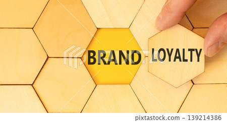 Brand loyalty words symbol. Concept words Brand loyalty on beautiful wooden puzzles. Beautiful yellow background. Businessman hand. Business and Brand loyalty words concept. Copy space. Brand loyalty words symbol. Concept words Brand loyalty on beautiful wooden puzzles. Beautiful yellow background. Businessman hand. Business and Brand loyalty words concept. Copy space. 139214386
