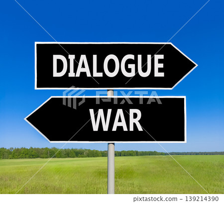 Dialogue instead war symbol. Concept words Dialogue and War on beautiful black road sign. Beautiful blue sky green grass background. Social and dialogue instead war concept. Copy space. 139214390