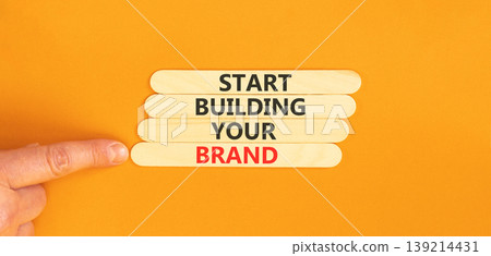 Start building your brand words symbol. Concept words Start building your brand on beautiful wooden sticks. Beautiful orange background. Business start building your brand concept. Copy space. Start building your brand words symbol. Concept words Start building your brand on beautiful wooden sticks. Beautiful orange background. Business start building your brand concept. Copy space. 139214431