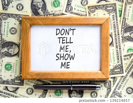 Tell or show symbol. Concept words Do not tell me, show me on beautiful wooden picture frame. Beautiful dollar bills background. Dollar bills. Business tell or show concept. Copy space. Tell or show symbol. Concept words Do not tell me, show me on beautiful wooden picture frame. Beautiful dollar bills background. Dollar bills. Business tell or show concept. Copy space. 139214857