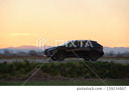SUV car driving fast on intercity road at sunset. Highway traffic in evening SUV car driving fast on intercity road at sunset. Highway traffic in evening 139214867