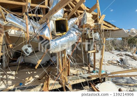 Storm surge caused by hurricane wind severe damaged residential houses on ocean shore. Natural disaster consequences in Florida Storm surge caused by hurricane wind severe damaged residential houses on ocean shore. Natural disaster consequences in Florida 139214906