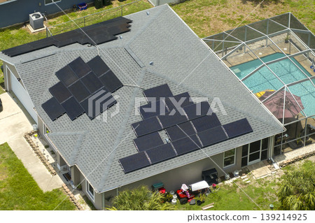 Solar panels on residential house rooftop. Photovoltaic sells for producing of clean electrical energy in suburban rural area. Concept of investment in autonomous home Solar panels on residential house rooftop. Photovoltaic sells for producing of clean electrical energy in suburban rural area. Concept of investment in autonomous home 139214925
