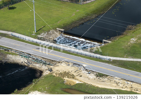 Roadworks site. Reconstruction of damaged road bridge destroyed by river after flood water washed away asphalt. Rebuilding of ruined transportation infrastructure Roadworks site. Reconstruction of damaged road bridge destroyed by river after flood water washed away asphalt. Rebuilding of ruined transportation infrastructure 139215026