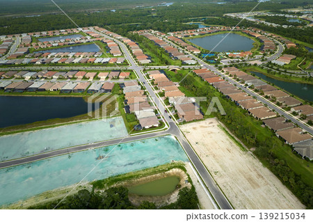 Real estate development with tightly located family houses under construction in Florida suburban area. Concept of growing american suburbs Real estate development with tightly located family houses under construction in Florida suburban area. Concept of growing american suburbs 139215034