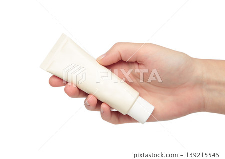 Beige cream tube in woman hands isolated on white background. Skin care concept. Beige cream tube in woman hands isolated on white background. Skin care concept. 139215545