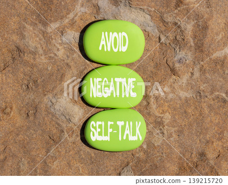 Avoid negative self-talk symbol. Concept words Avoid negative self-talk on beautiful green stones. Beautiful stone beach background. Business psychology avoid negative self-talk concept. Copy space. Avoid negative self-talk symbol. Concept words Avoid negative self-talk on beautiful green stones. Beautiful stone beach background. Business psychology avoid negative self-talk concept. Copy space. 139215720