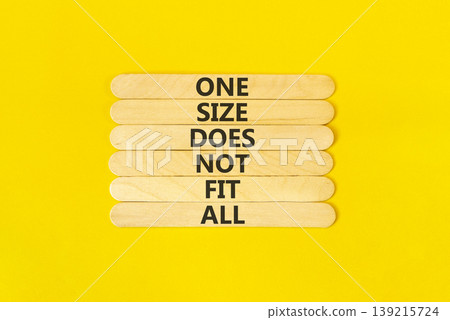 One size does not fit all symbol. Concept words One size does not fit all on wooden stick. Beautiful yellow table yellow background. One size does not fit all business concept. Copy space. 139215724