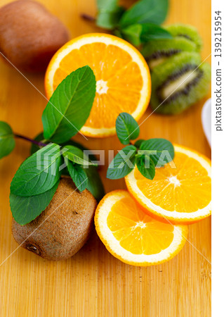 fresh orange slices with kiwi on wooden board background 139215954