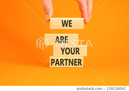We are your partner symbol. Concept words We are your partner on beautiful wooden blocks. Beautiful orange background. Businessman hand. Business motivational we are your partner concept. Copy space. 139216042