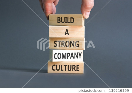 Strong company culture symbol. Concept words Build a strong company culture on beautiful wooden blocks. Beautiful grey paper background. Business strong company culture concept. Copy space. 139216399