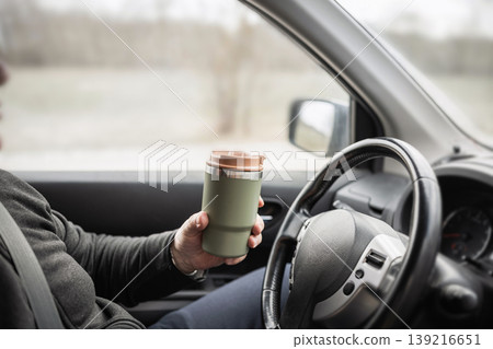 Driver Holding Reusable Coffee Cup Inside Car Driver Holding Reusable Coffee Cup Inside Car 139216651